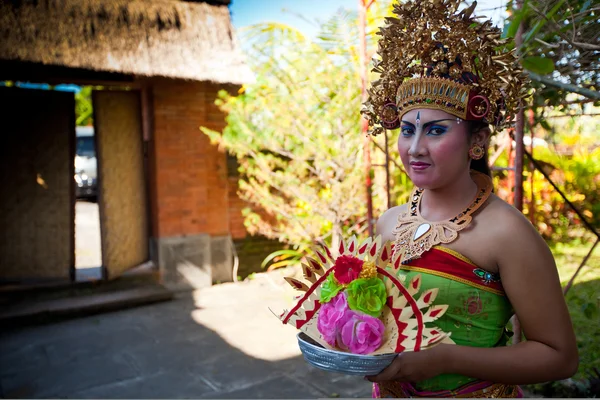 BALI, INDONÉSIE 9 AVRIL : Une fille balinaise posant pour un randonneur devant un costume de danse classique balinais le 9 avril 2012 à Bali, Indonésie. tenue formelle est un spectacle culturel très populaire sur Bali . — Photo